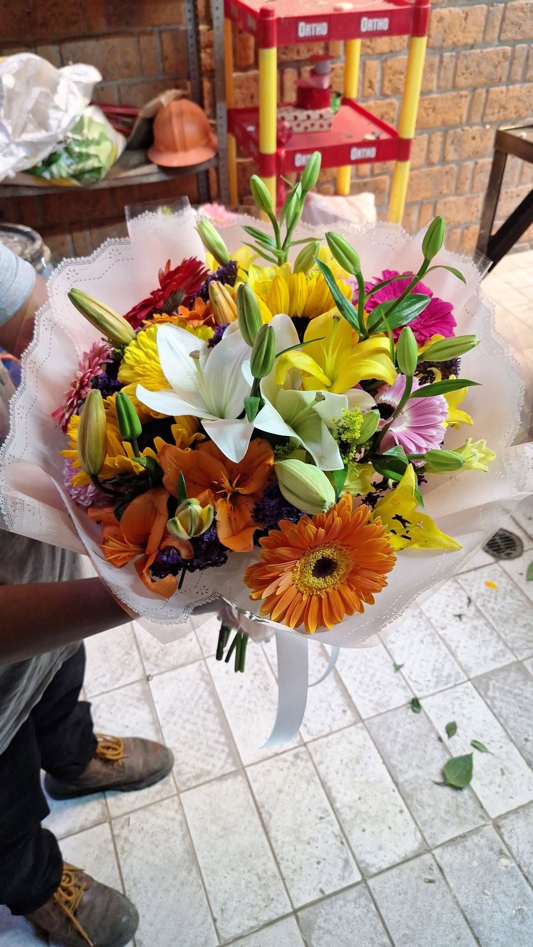 Ramo colorido con lirios, gerberas y girasoles envuelto en papel